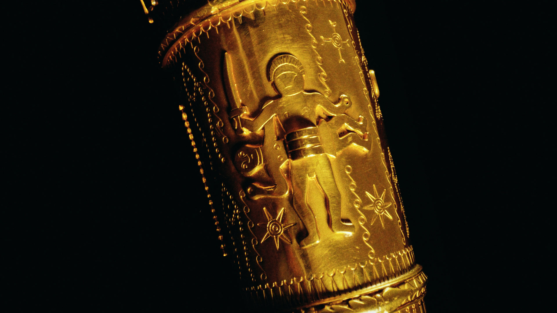 A figure holding a horn, on the gold