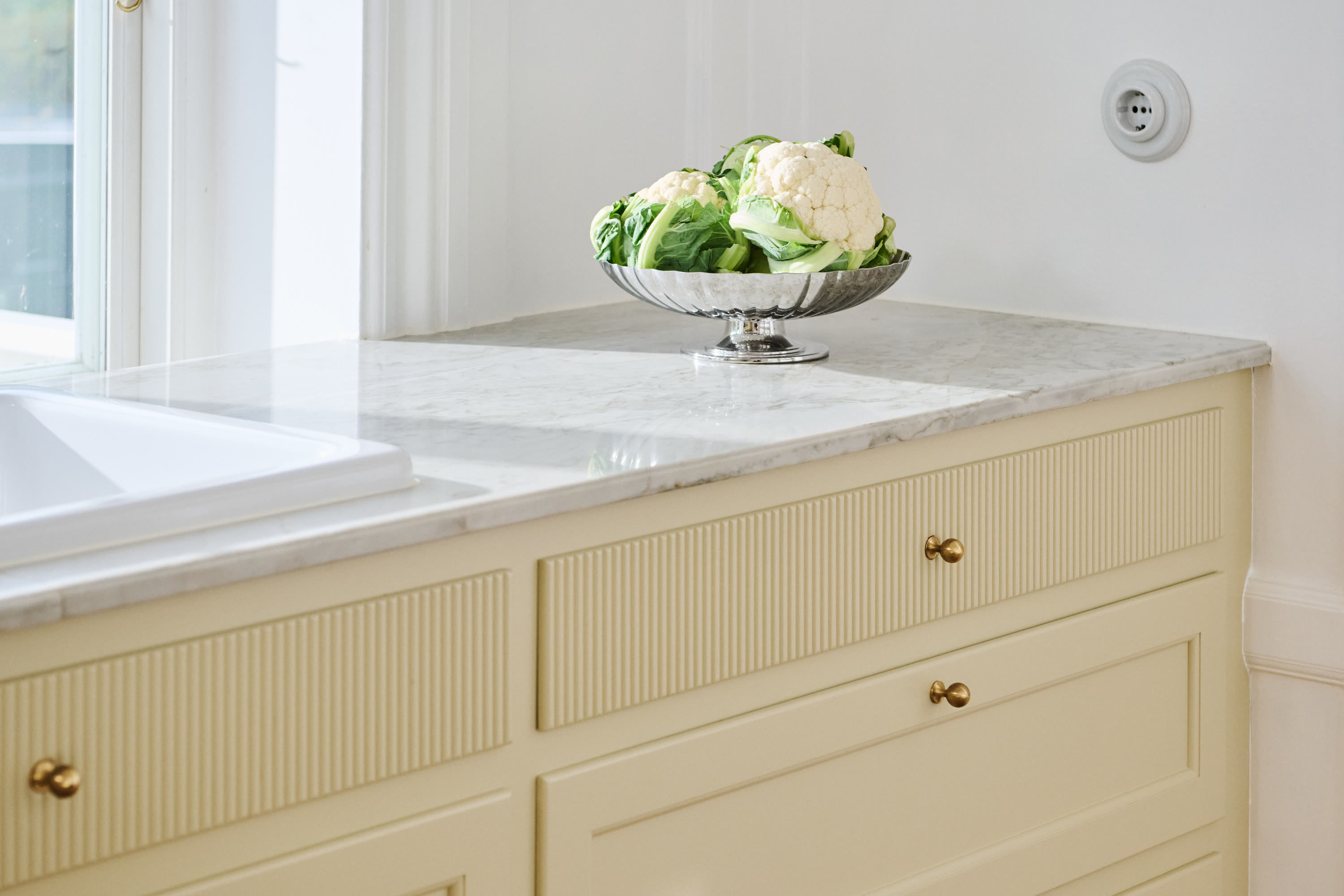 The worktop by the sink with a bowl of cauliflower