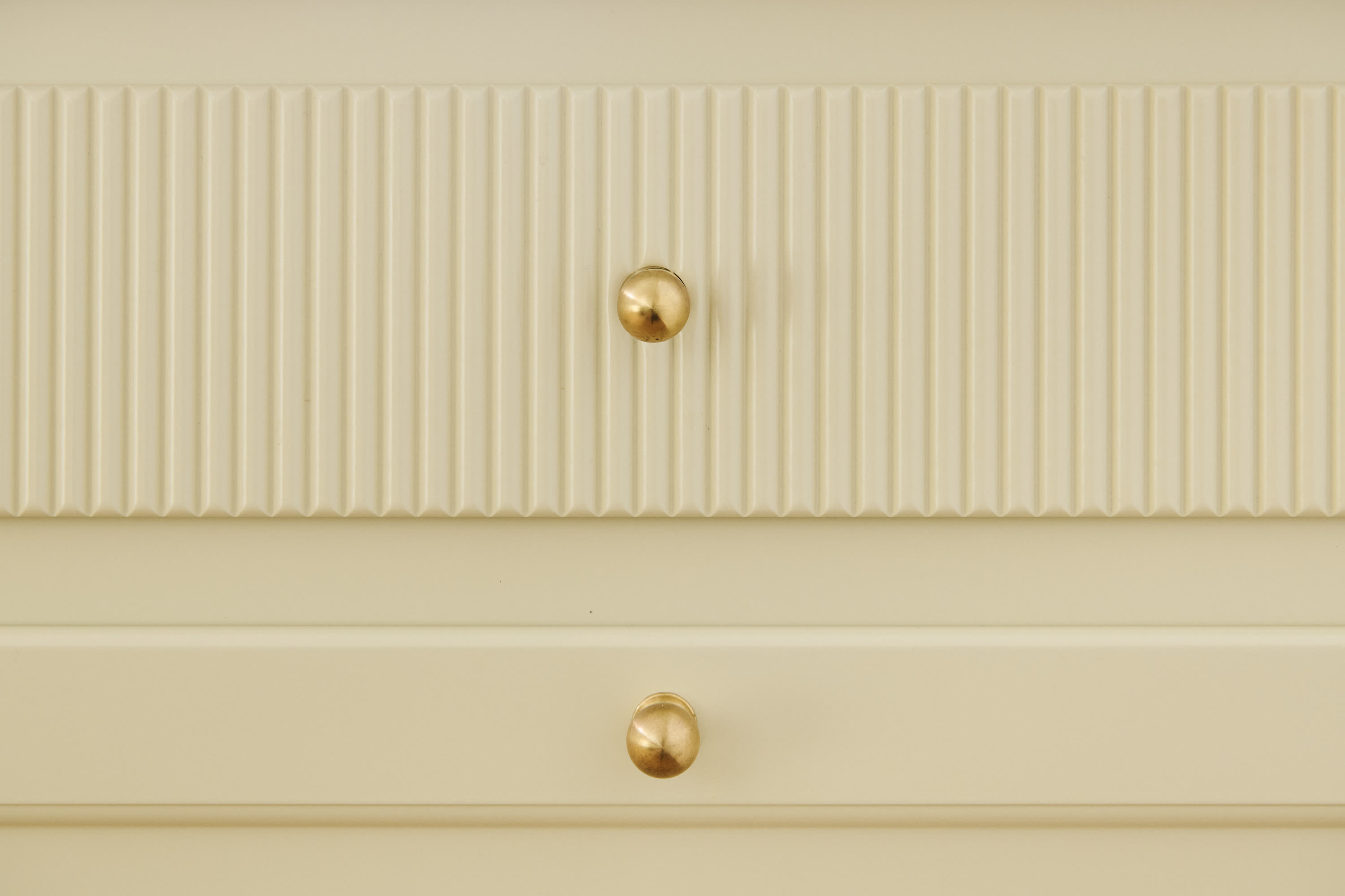 A fluted drawer front with a brass knob