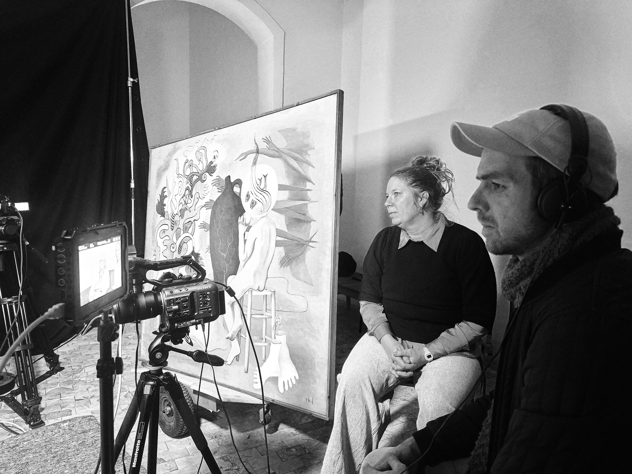 Participants in front of a painting on set