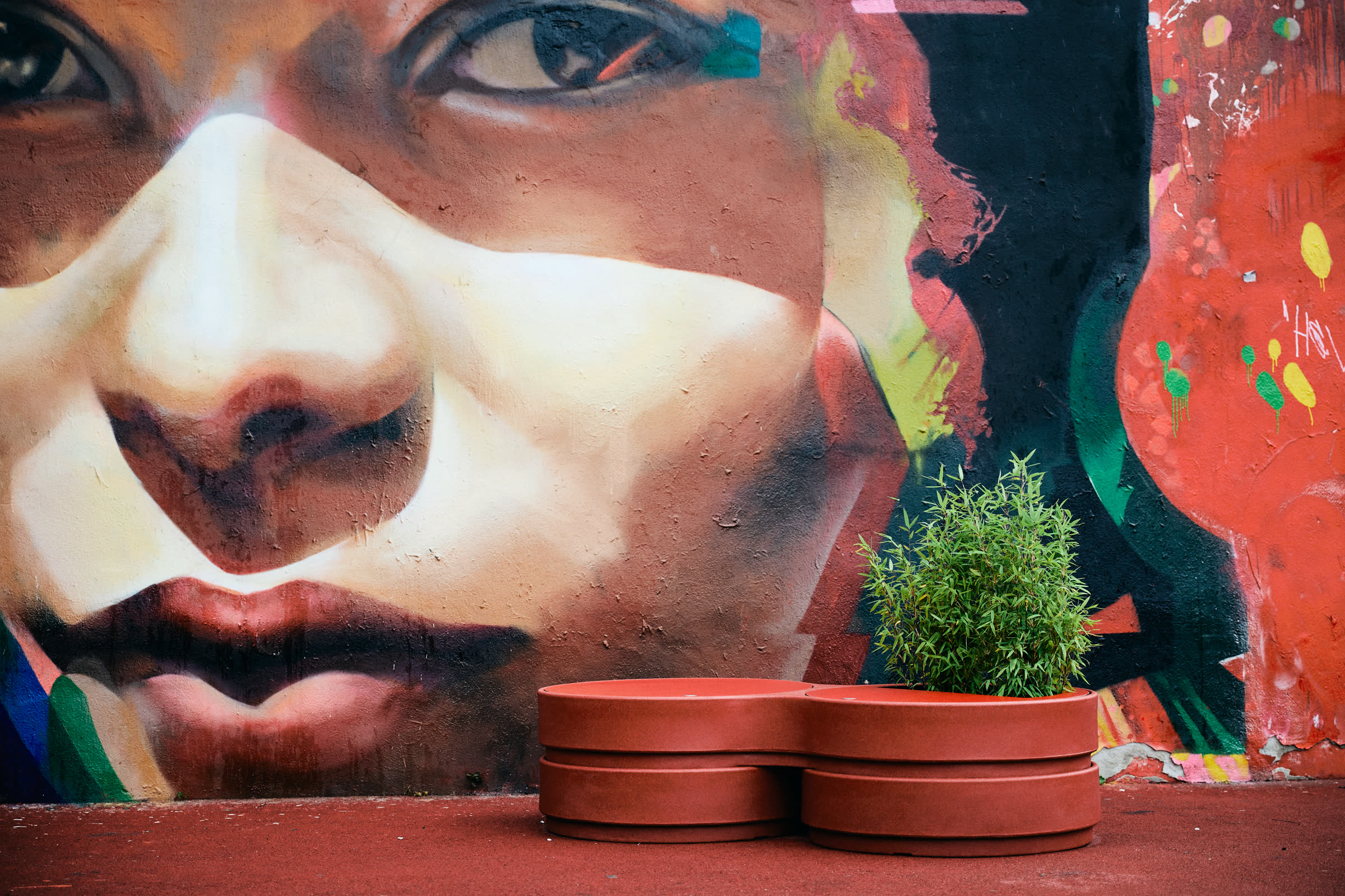 A red Circus planter in front of a mural