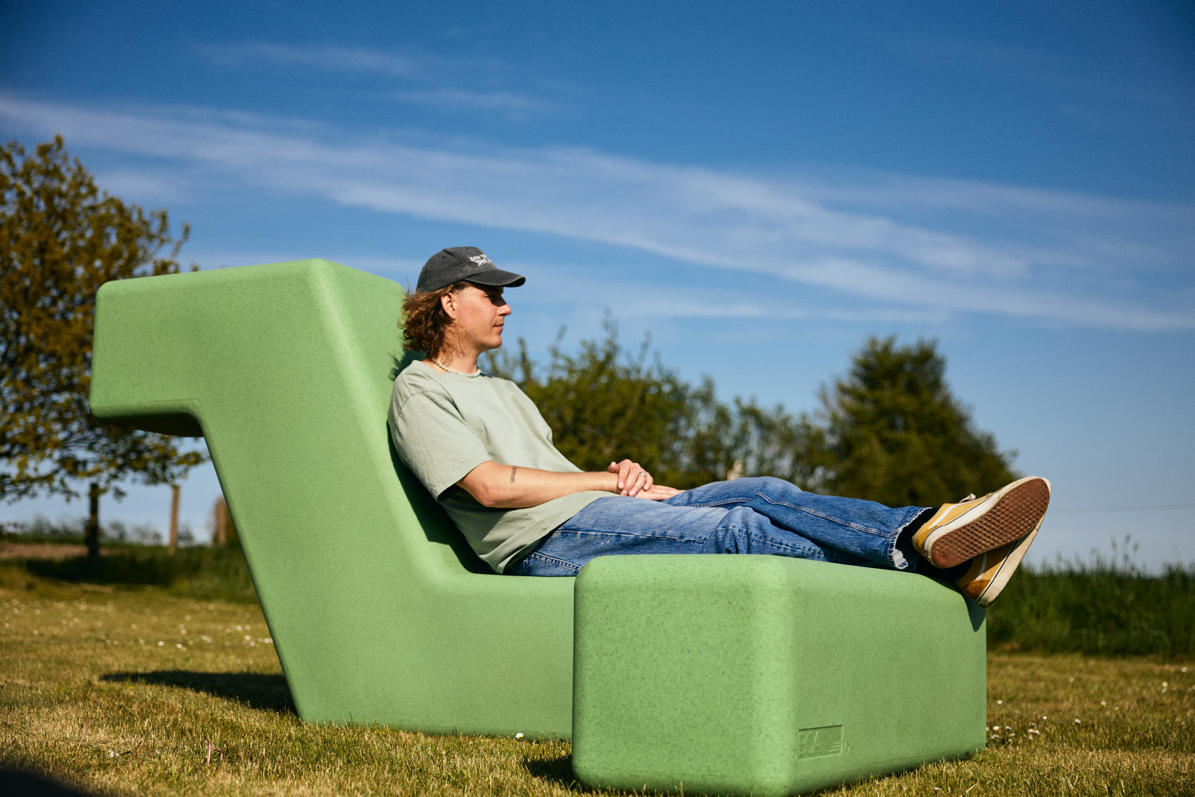 A green LOOP lounger by the water