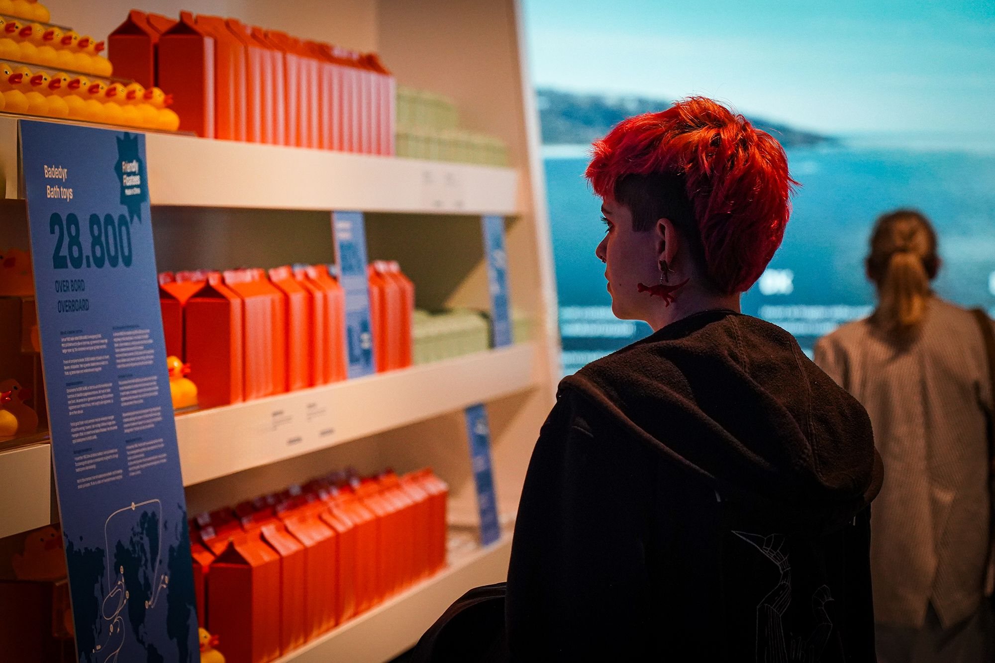Shelves in the Greenlandic shop with the sea projected behind