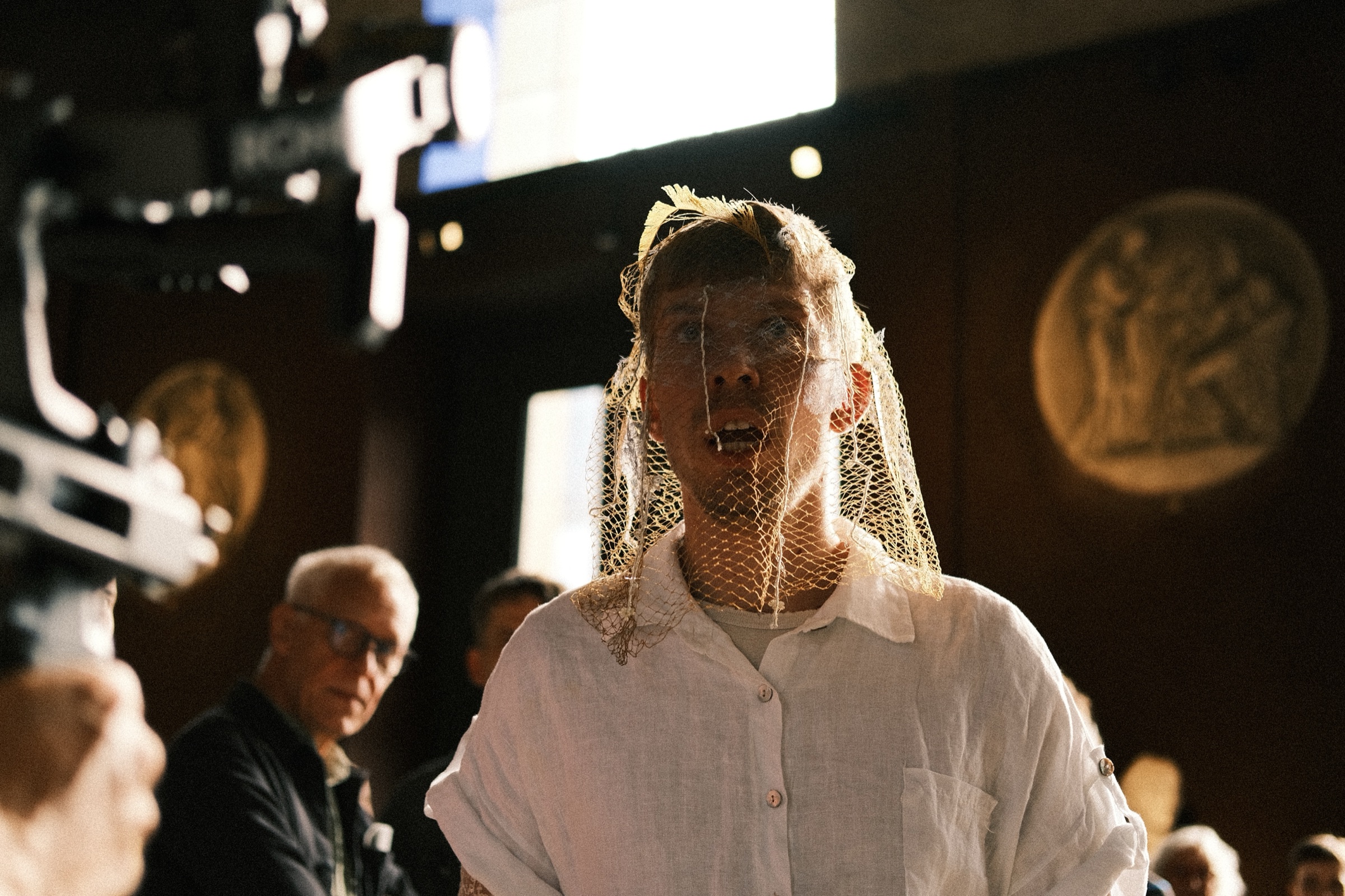 The singer in a veil among the audience in the entrance hall