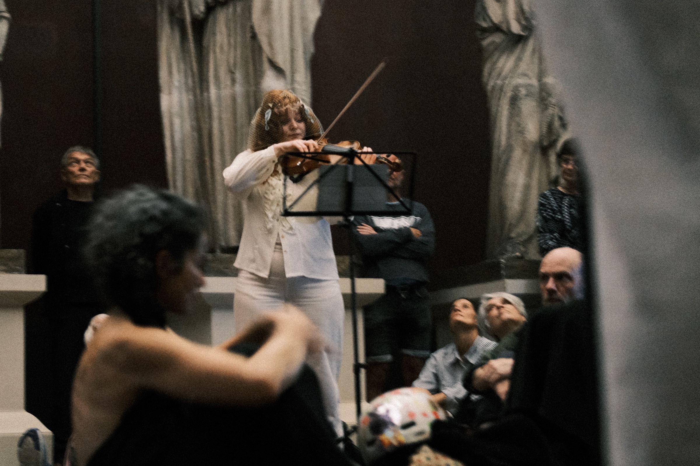 The violinist playing among the seated audience