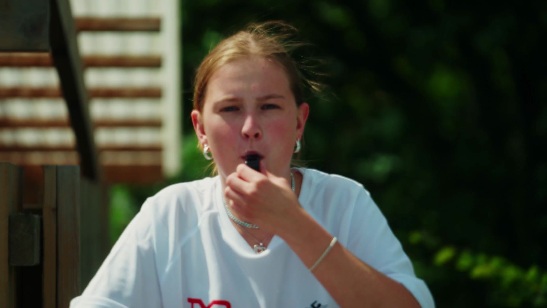 The lifeguard blowing her whistle