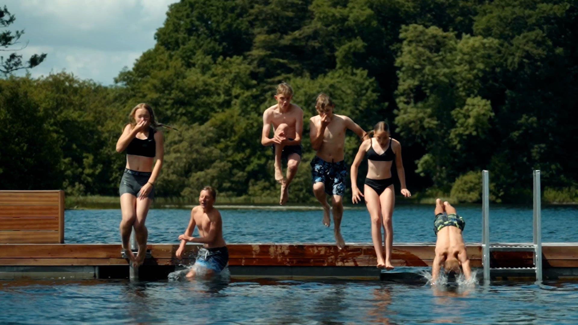 Young people jumping off the jetty